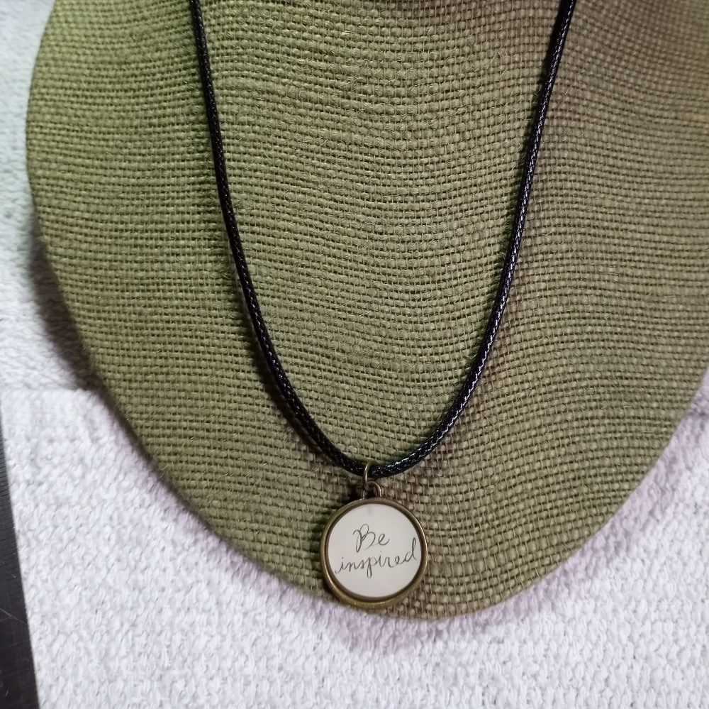Goldtone be inspired round pendant on black cord necklace